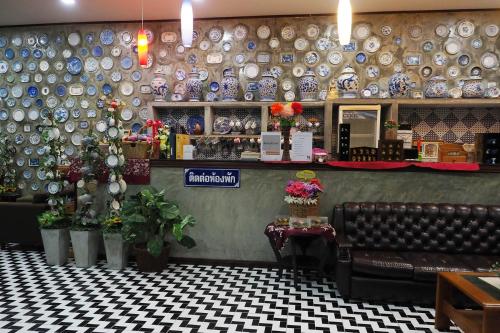 a restaurant with a wall of plates on the wall at Nawamit Home Garden in Nakhon Si Thammarat