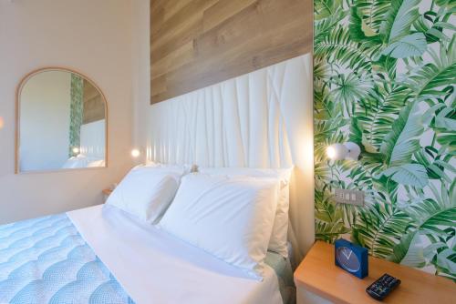 a bedroom with a bed and a wall with plants at Hotel Nuova Medusa Rimini in Rimini