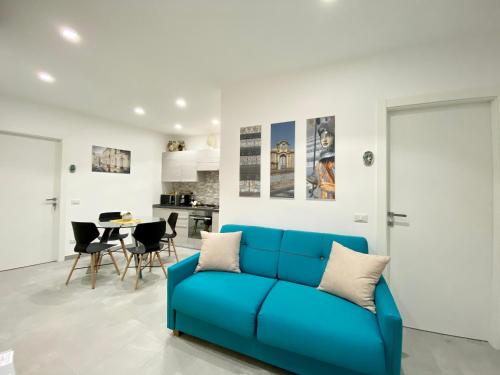 ein Wohnzimmer mit einem blauen Sofa und einem Tisch in der Unterkunft Appartamento al centro storico in Caltagirone
