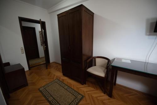 a room with a desk and a chair and a cabinet at Pension Arena in Cluj-Napoca