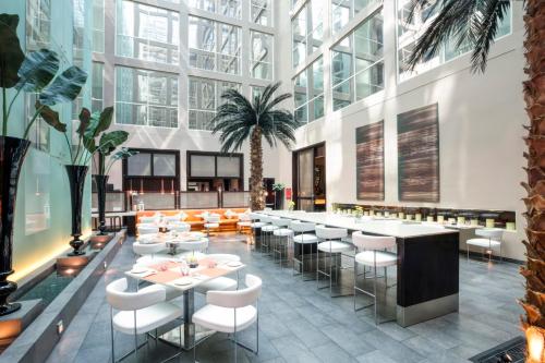 un rendering di un ristorante con tavoli e sedie di Centro Barsha - by Rotana a Dubai