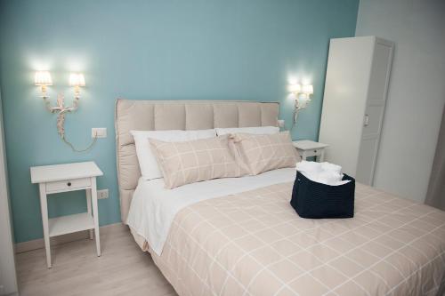 - une chambre avec un grand lit et un mur bleu dans l'établissement Gli Archi dei Diavoli, à Salerne