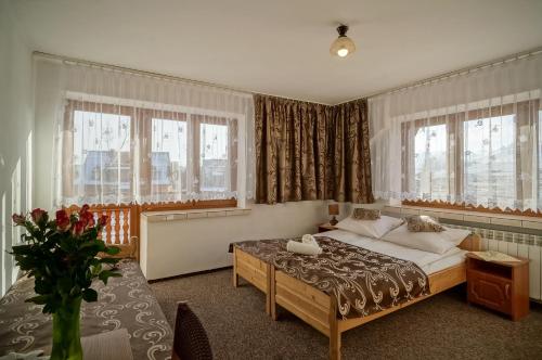 ビャウカにあるDom Wypoczynkowy u Niedzielskichのベッドルーム1室(ベッド1台、窓2つ付)