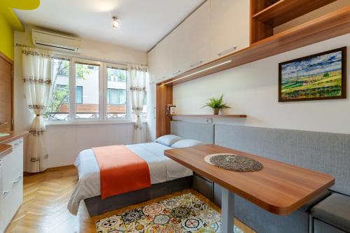 Habitación pequeña con cama y mesa de madera. en Studio DOLCE VITA en Varna