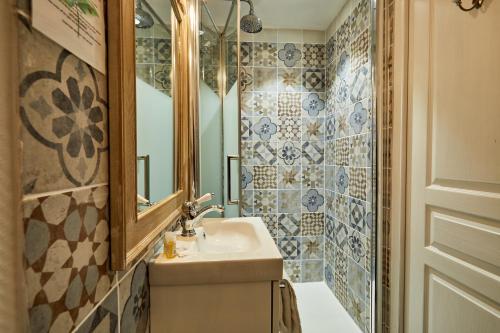 a bathroom with a sink and a mirror and a tub at Hotel Saint Etienne in Caen