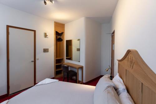 a bedroom with a bed and a desk in a room at Amsterdam Wiechmann Hotel in Amsterdam