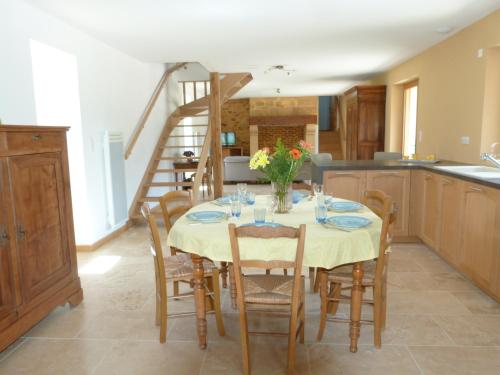 une salle à manger avec une table, des chaises et un escalier dans l'établissement Maison Périgord Noir près de Lascaux, Montignac, Sarlat, Périgueux, à Fleurac