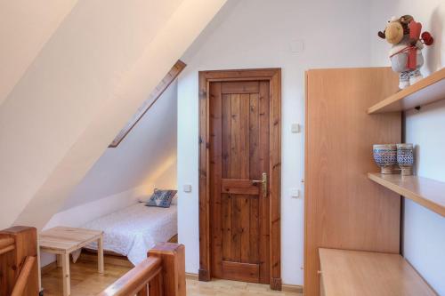 1 dormitorio con 1 cama y puerta de madera en Torán by Totiaran en Baqueira-Beret