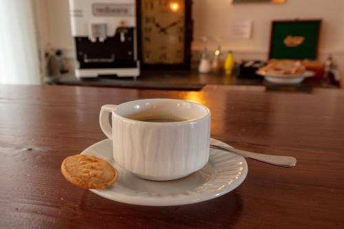 a cup of coffee and a cookie on a table at Amsterdam Wiechmann Hotel in Amsterdam