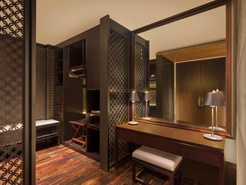 a dressing room with a desk and a mirror at The Apurva Kempinski Bali in Nusa Dua