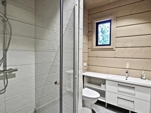 a bathroom with a shower and a toilet and a sink at Levillas Kuppimaantie Villas in Levi