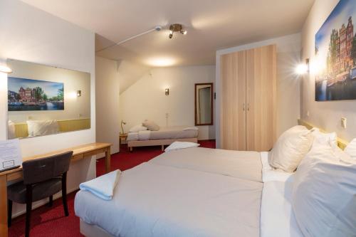 a hotel room with two beds and a television at Amsterdam Wiechmann Hotel in Amsterdam