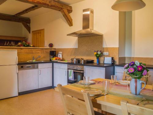 uma cozinha com uma mesa, um frigorífico e um fogão em Rittergut Reudnitz em Reudnitz