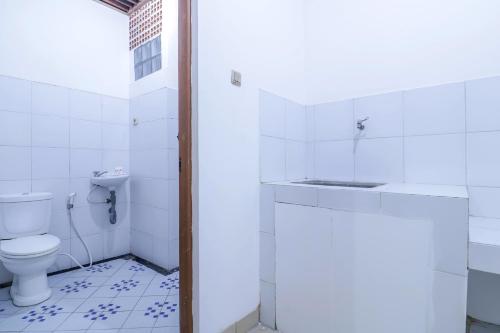 La salle de bains est pourvue de toilettes et d'un lavabo. dans l'établissement SUPER OYO 1755 De'balcon Accomodation Near Ngurah Rai Airport, à Kuta