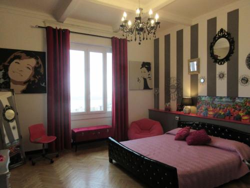 a bedroom with a bed and a window and a chandelier at Doria House 23 in Genova