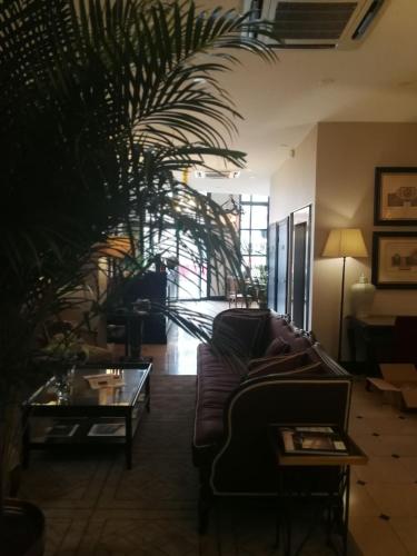 a living room with a couch and a large plant at Hotel De La Treille in Lille