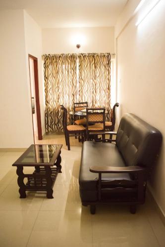 a living room with a couch and a table at Ruby Residency in Kozhikode