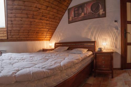 a large bed in a bedroom with a wooden ceiling at Apartament Villa Toscana in Jaworki