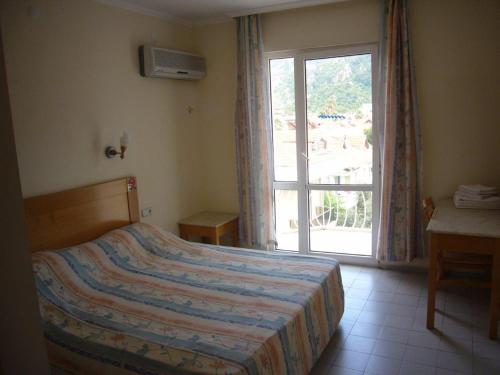 a bedroom with a bed and a large window at Avlu 4 in Marmaris