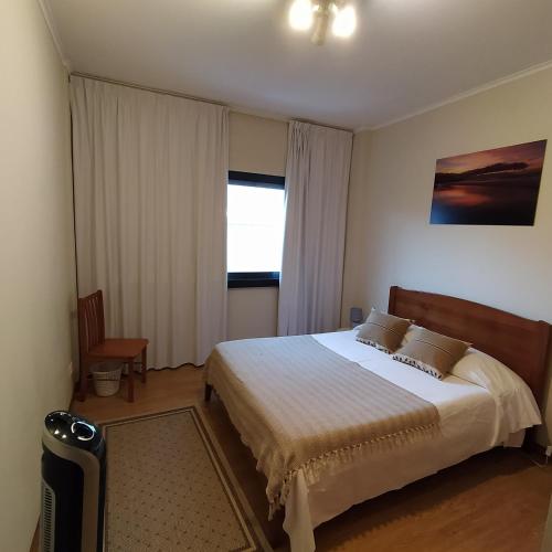 a bedroom with a large bed and a window at Apartamento Solmar in Ponta Delgada