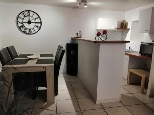 uma sala de jantar com uma mesa e um relógio na parede em Ty bily em Plaudren