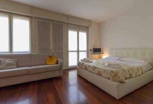 a bedroom with a large bed and a couch at STUDIO ROMA 41 - Affitti Brevi Italia in Lecco