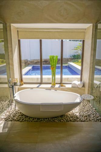 a large white tub in a bathroom with a window at Kandaya Resort in Daanbantayan
