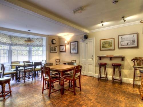 a dining room with a table and chairs in a room at The Talbot in Iwerne Minster