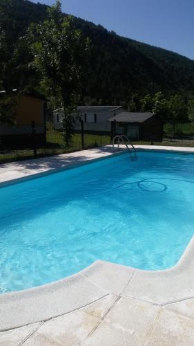 una gran piscina azul con un tobogán. en Resort Camping Solopuent, en Castiello de Jaca