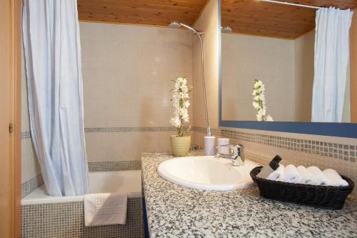 La salle de bains est pourvue d'un lavabo, d'un miroir et d'une baignoire. dans l'établissement BCNGOTIC 50, à Barcelone