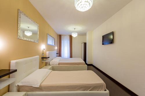 ein Krankenhauszimmer mit 2 Betten und einem Spiegel in der Unterkunft Sweetdreams Plaça Civica in Alghero