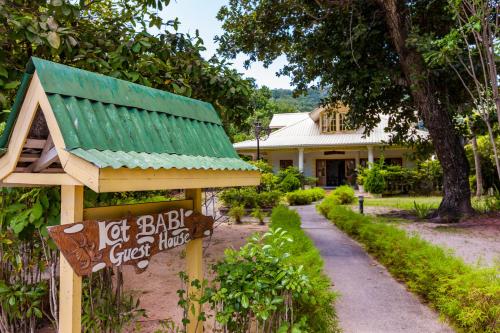 a house with a green roof next to a garden at Kot Babi in La Digue