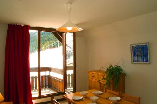 a dining room with a table and a large window at La résidence du Pleynet aux 7 Laux in La Ferrière