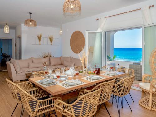 a dining room with a table and chairs and the ocean at Villa Sky in Skaleta