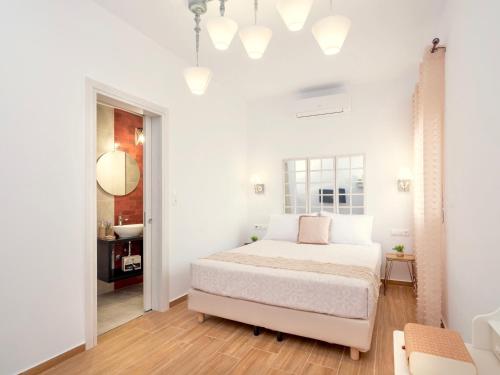 a white bedroom with a bed and a mirror at Villa Sky in Skaleta