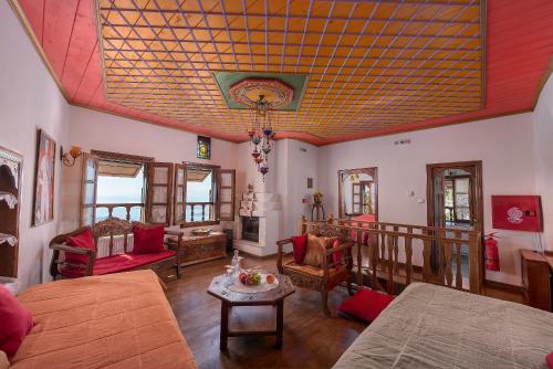 a living room with a couch and a table at Archontiko Melanthi in Makrinítsa