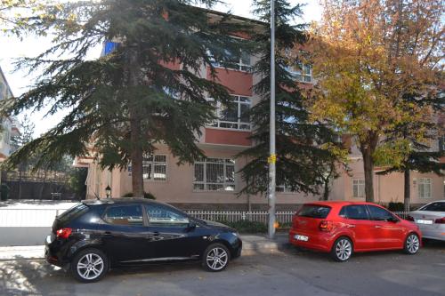 zwei Autos auf einem Parkplatz vor einem Gebäude geparkt in der Unterkunft Evodak Apartment in Ankara