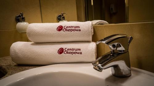 a pile of towels sitting on top of a bathroom sink at Centrum Okopowa 55 in Warsaw