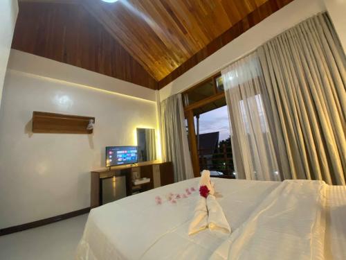 a bedroom with a white bed with a window at Ananda Resort in Panglao