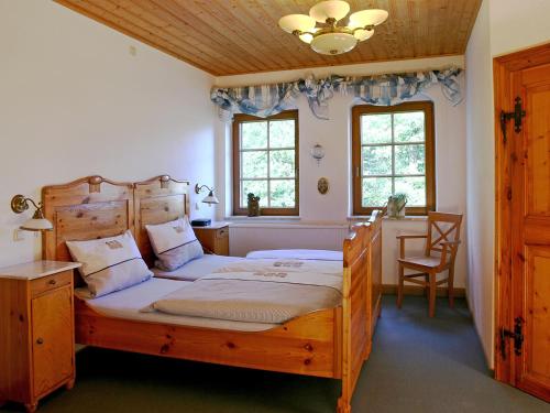 a bedroom with two beds and a table and two windows at Ferienhof "Alte Försterei" in Knau