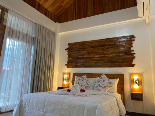 a bedroom with a white bed with flowers on it at Ananda Resort in Panglao