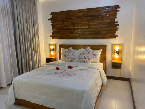 a bedroom with a white bed with flowers on it at Ananda Resort in Panglao