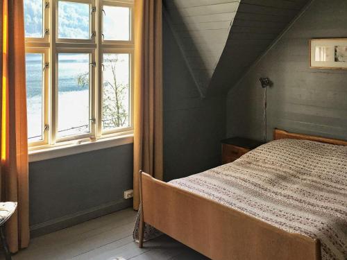 ein Schlafzimmer mit einem Bett und zwei Fenstern in der Unterkunft Holiday home øystese in Øystese