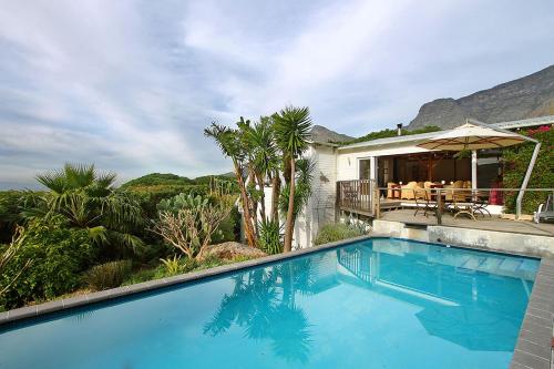 a swimming pool in front of a house at Cape Paradise Lodge and Apartments in Cape Town