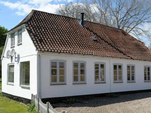 a small white house with a brown roof at 4 person holiday home in Broager in Broager
