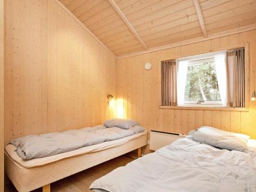 KramnitseにあるThree-Bedroom Holiday home in Rødby 6のベッド2台と窓が備わる客室です。