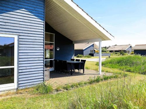 a porch with a table on the side of a house at 6 person holiday home in Ulfborg in Fjand Gårde