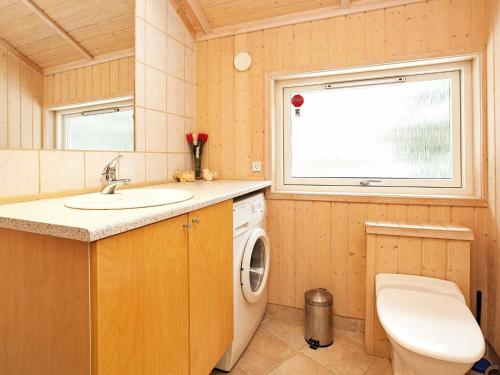 a bathroom with a sink and a washing machine at 8 person holiday home in Rødby-By Traum in Kramnitse