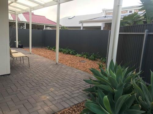 a patio with a fence and a chair in a yard at Gawler Townhouse U1 1 Bedroom in Gawler