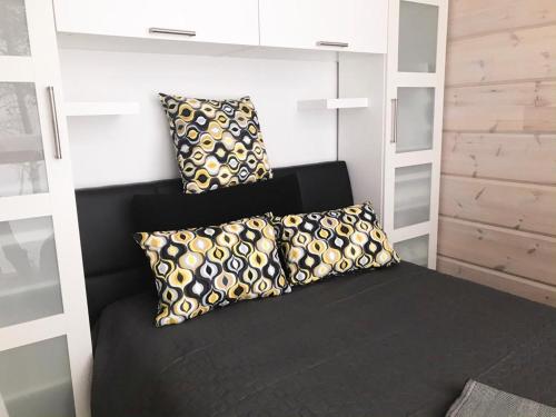 a bed in a room with two pillows on it at Villa Váibmu in Inari